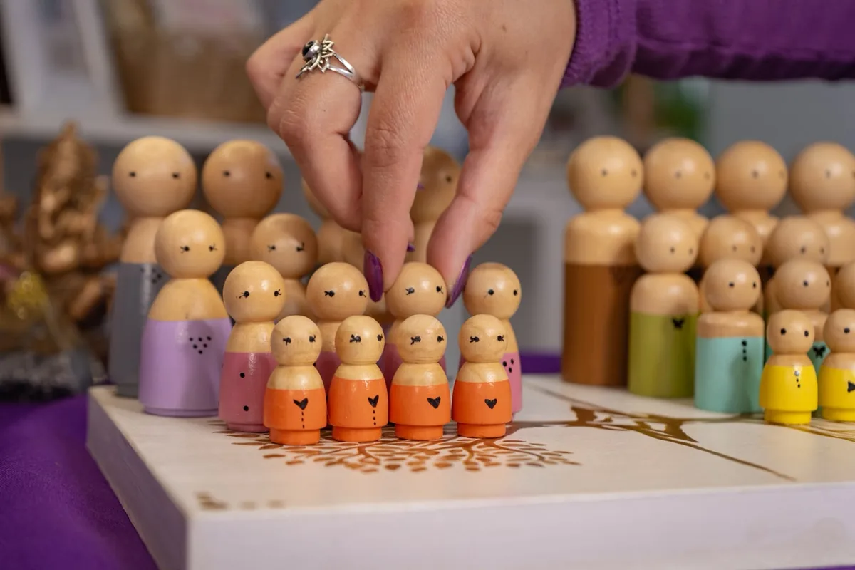 Muñecos de madera dispuestos sobre un tablero con un árbol genealógico