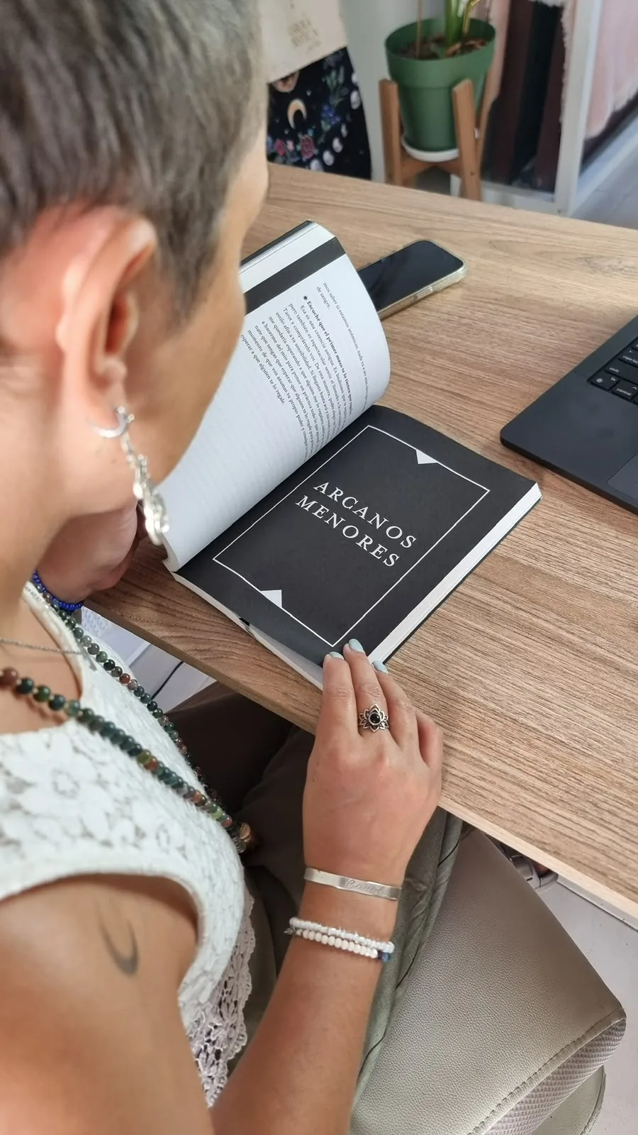 Una alumna leyendo el manual del curso abierto en la página de los Arcanos Menores