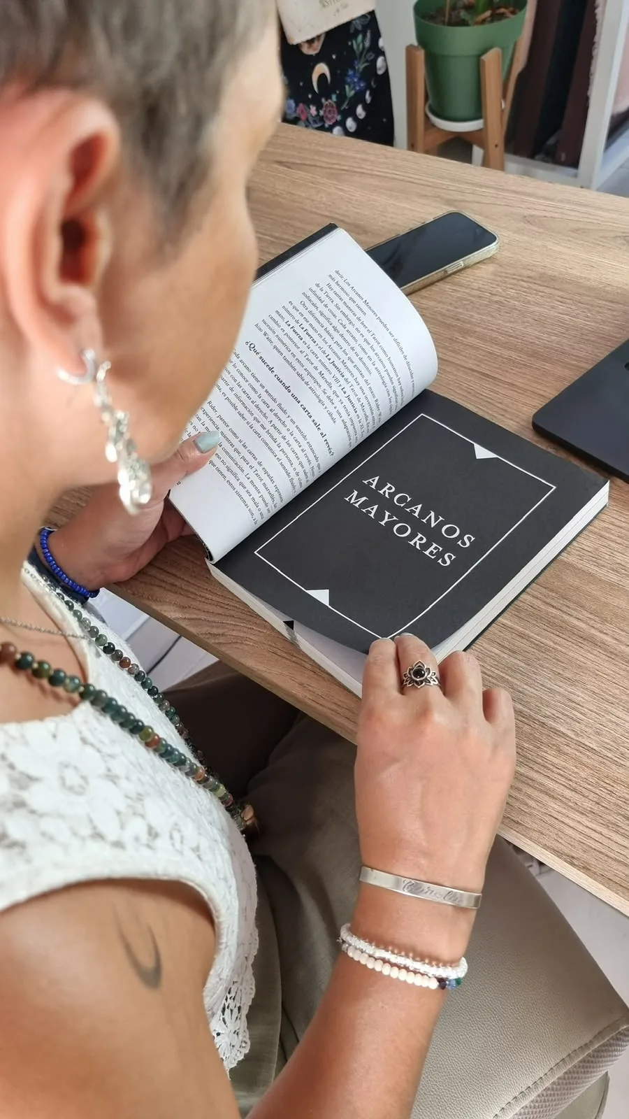 Una alumna leyendo el manual del curso abierto en la página de los Arcanos Mayores