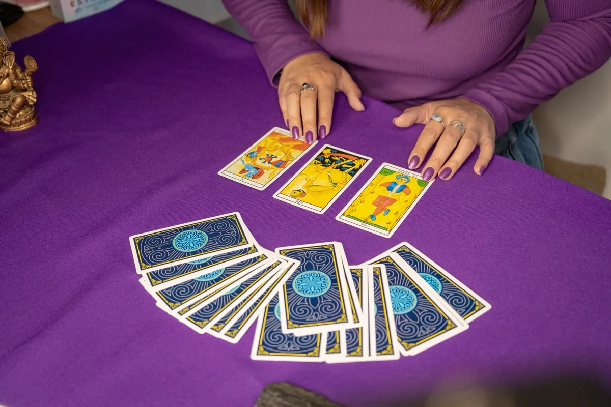 Vale tirando las cartas del tarot de Marsella sobre un paño violeta