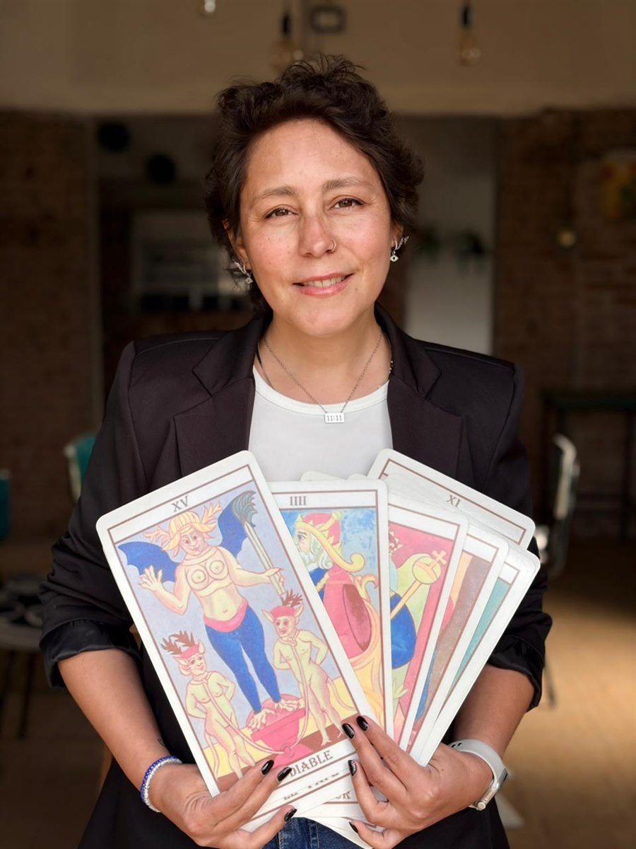 Valeria Vassallo, tarotista en Chivilcoy, con un abanico de cartas de tarot de Marsella